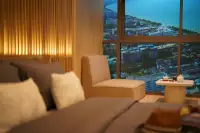 Studio Condo for Sale at SKYPARK Lucean Jomtien Pattaya bedside seating nook with armchair and high-rise Pattaya coastline view