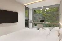 1 Bedroom Condo for Sale at Celine Wongamat minimalist bedroom with floor-to-ceiling glass windows, built-in desk and lush garden view