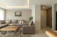 2 Bedroom Condo for Sale at Zensiri Estates and Residences spacious living room with L-shaped sofa, wood coffee table, and hallway