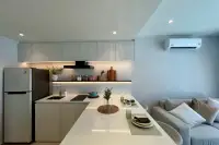 1 Bedroom Condo for Sale at Celine Wongamat: Contemporary kitchen with light wood cabinets, white countertops, and sleek appliances.