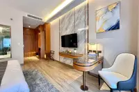 Studio Condo for Sale at Wyndham Jomtien Pattaya: contemporary living space with TV, desk, chair, and abstract art on the wall.