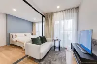 1 Bedroom Condo for Sale at Aquarous Jomtien Pattaya bright bedroom with blue feature wall, white upholstered bed and floor-to-ceiling curtains