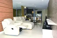 3 Bedroom Condo for Sale at Apus open-plan living room with white leather recliner sofa and dining area