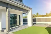 4 Bedroom House for Sale in Pong, side exterior with artificial grass, covered patio, and small pool area.