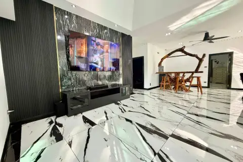 3 Bedroom House for Sale in Nong Prue living room with large TV, black and white marble floor, and unique wooden bar.