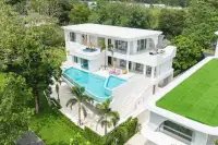 6 Bedroom House for Sale in Huai Yai aerial view of white modern villa with large infinity pool and tropical garden