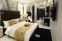 Studio Condo for Sale at Grand Solaire Noble: Bedroom with a large bed, decorative pillows, and a view of the dining area.