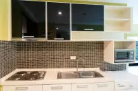 1 Bedroom Condo for Sale at Wongamat Privacy kitchen with dark mosaic tile backsplash, electric hob, stainless steel sink, and wall cabinets