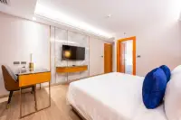 2 Bedroom Condo for Sale at Wyndham Jomtien Pattaya - bedroom with large bed, wall-mounted TV, and desk area.