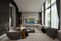 4 Bedroom House for Sale at Cascade luxury living room with L-shaped sofa, marble TV wall, dark stone accent wall, and tall glazed windows