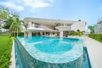 8 Bedroom House for Sale in Huai Yai wide infinity pool with mosaic tiles and contemporary white villa exterior