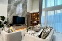 5 Bedroom House for Sale at Impress House Village double-height living room with marble feature wall and large TV unit