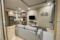 1 Bedroom Condo for Sale at Cetus Beachfront spacious living room viewed from entrance with kitchen, sofa, and bicycle wall decor