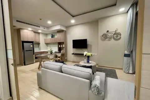1 Bedroom Condo for Sale at Cetus Beachfront spacious living room viewed from entrance with kitchen, sofa, and bicycle wall decor