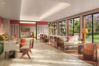 D Condo Vite bright communal lounge area with eclectic furniture, terrazzo flooring, and floor-to-ceiling windows overlooking gardens