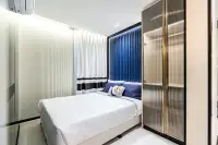 2 Bedroom Condo for Sale at Embassy Life second bedroom with blue velvet headboard, gold-framed glass wardrobe and white curtains