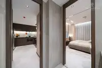 1 Bedroom Condo for Sale at Panora Estuaria: Living room with a long sofa, large TV, and floor-to-ceiling curtains.