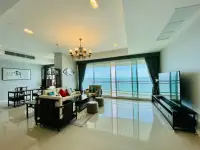 3 Bedroom Condo for Sale at Reflection Jomtien Beach living room with sea view balcony and Asian-style furniture