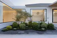 4 Bedroom House for Sale at AVANI Pool Villa landscaped garden courtyard with manicured shrubs and floor-to-ceiling glass walls