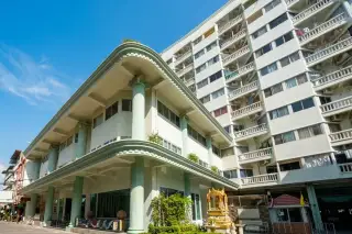 Jomtien Thip Condotel exterior showing the main entrance with decorative columns and a multi-story white building.