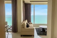 2 Bedroom Condo for Sale at Del Mare spacious living room with cream sofa, dark rug, and dual floor-to-ceiling ocean view windows