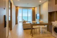 1 Bedroom Condo for Sale at Cetus Beachfront open-plan living and dining area with sofa, glass table, and ocean view balcony