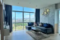 1 Bedroom Condo for Sale at The Twin Tower Jomtien Beach Pattaya furnished living room with L-shaped sofa and floor-to-ceiling city view windows