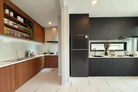 5 Bedroom House for Sale at The Lake Huay Yai dual kitchen with wood cabinets, black matte units, marble countertops, and marble tile floors
