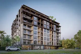 Siam Oriental Beach modern condo building exterior with balconies, ground-floor shops, and a white car parked.