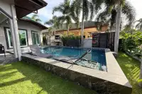 3 Bedroom House for Sale in Nong Prue small rectangular swimming pool with two submerged lounge chairs and green grass.
