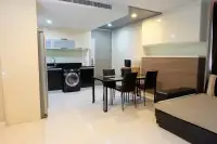 3 Bedroom Condo for Sale at Apus dining area with black glass table, kitchen with washing machine and white upper cabinets