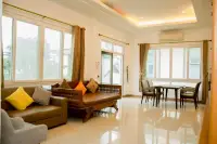 6 Bedroom House for Sale & Rent at Amorn Village, bright living area with sofas, dining table, and large windows.