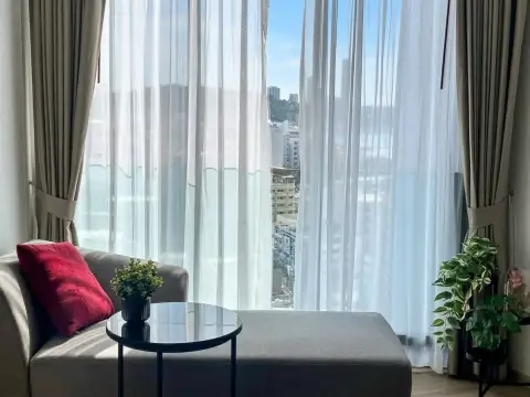 1 Bedroom Condo for Sale at EDGE Central Pattaya living area with sheer curtains and city view