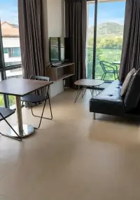1 Bedroom Condo for Sale at Sea Zen open living area with TV console, sofa and floor-to-ceiling windows