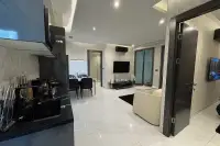 2 Bedroom Condo for Sale at Zenith Pattaya modern kitchen and dining area with black cabinetry and marble tile flooring