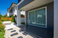 3 Bedroom House for Sale at Baan Pruksa Nara Chaiyapruek covered patio with sliding glass doors and pebble stone garden