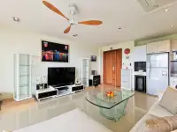 1 Bedroom Condo for Sale at The Park Jomtien living room with TV unit, glass coffee table and kitchen area