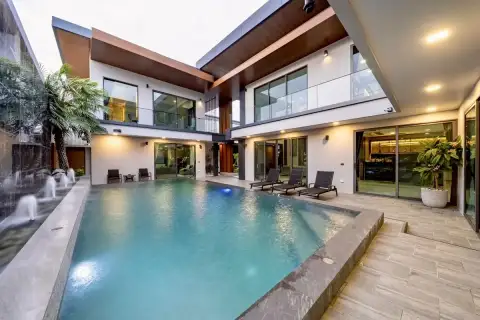6 Bedroom House for Sale at M Mountain Village large private pool with water jets, palm tree, and illuminated two-storey villa facade