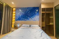 1 Bedroom Condo for Sale & Rent at Arom Wongamat king bed with blue abstract headboard mural, gold backlit shelves, and built-in wardrobe