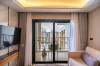 1 Bedroom Condo for Sale at Wyndham Jomtien Pattaya: Living room with sofa, desk, and balcony access through curtains.