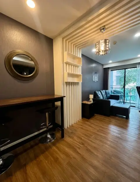 1 Bedroom Condo for Sale at Dusit Grand Park 1 living room with black leather sofa and balcony access