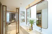 2 Bedroom Condo for Sale at Arom Jomtien ensuite bathroom with double vanity, arched mirror and glass shower partition