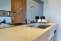 2 Bedroom Condo for Sale at Wyndham Jomtien Pattaya - bedroom with large bed, wall-mounted TV, and desk area.