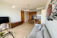 1 Bedroom Condo for Rent at Northpoint open-plan living and dining area with wooden kitchen cabinets and flat-screen TV
