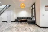 3 Bedroom House for Sale at Wongamat Exclusive Place spacious living room with L-shaped grey sofa and marble floor