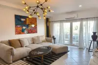 1 Bedroom Condo for Sale & Rent at View Talay Residence 1&2 living room with large colorful wall art, L-shaped sofa, and balcony access