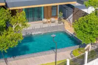 8 Bedroom House for Sale in Nong Prue, aerial view of a private swimming pool with outdoor seating area.