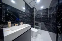 1 Bedroom Condo for Sale at Grand Solaire Noble bathroom with black marble walls white marble sink glass shower and toilet