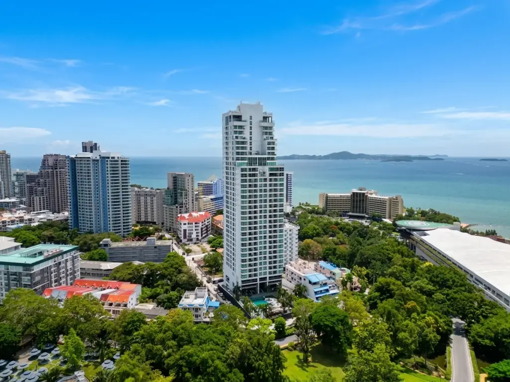 Sky Residences Pattaya aerial view of modern high-rise building overlooking the ocean, coastline, and city.