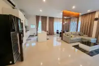 3 Bedroom House for Rent at Garden Ville 1 open-plan kitchen and living area with island counter and grey L-shaped sofa